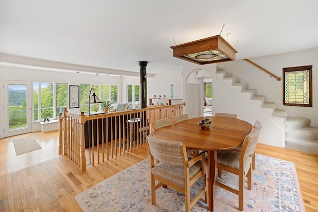 1065 Center Fayston Rd, Fayston, VT 05660 - dining area with light wood-style flooring, arched walkways, and stairway