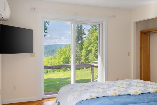 1065 Center Fayston Rd, Fayston, VT 05660 - bedroom with a wall mounted AC, access to exterior, light wood finished floors, and baseboards