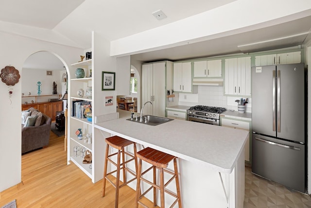 1065 Center Fayston Rd, Fayston, VT 05660 - kitchen with stainless steel appliances, a sink, arched walkways, and light countertops