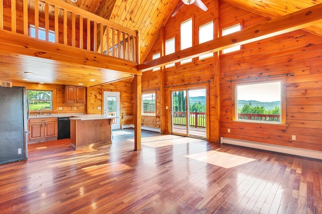 201 Deering Center Rd, Deering, NH 03244 - unfurnished living room with a baseboard heating unit, light wood finished floors, wood walls, high vaulted ceiling, and a sink
