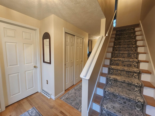 4 Edith Ave, Nashua, NH 03064 - stairs featuring wood finished floors, baseboards, and a textured ceiling