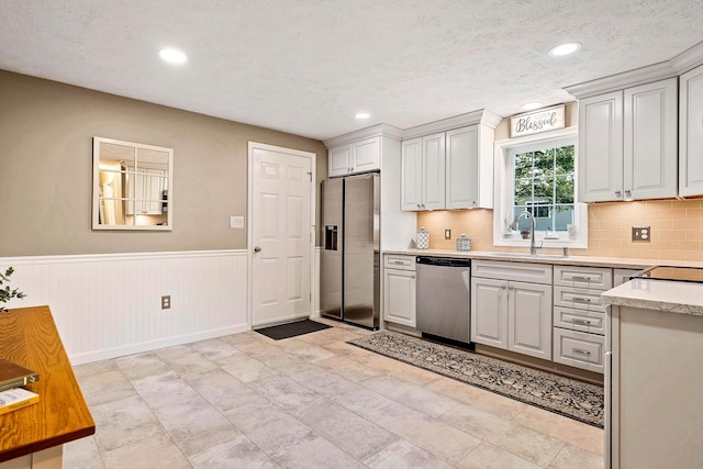4 Edith Ave, Nashua, NH 03064 - kitchen with stainless steel appliances, a sink, recessed lighting, a wainscoted wall, and tasteful backsplash