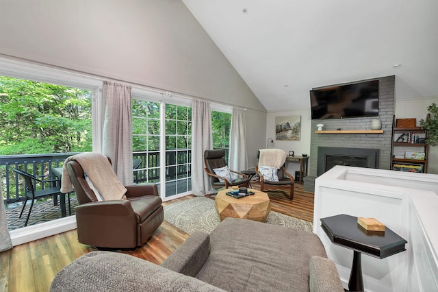 6 Chalet Dr, Gilford, NH 03249 - living area with high vaulted ceiling, a brick fireplace, and wood finished floors