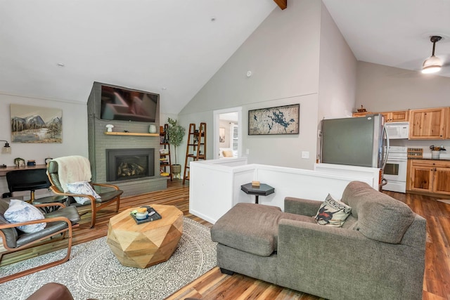 6 Chalet Dr, Gilford, NH 03249 - living area featuring high vaulted ceiling, dark wood-style flooring, a brick fireplace, and ceiling fan