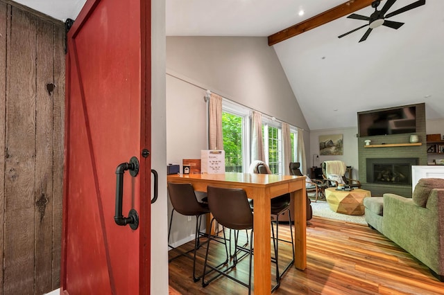 6 Chalet Dr, Gilford, NH 03249 - dining space featuring beam ceiling, wood finished floors, a brick fireplace, a ceiling fan, and high vaulted ceiling
