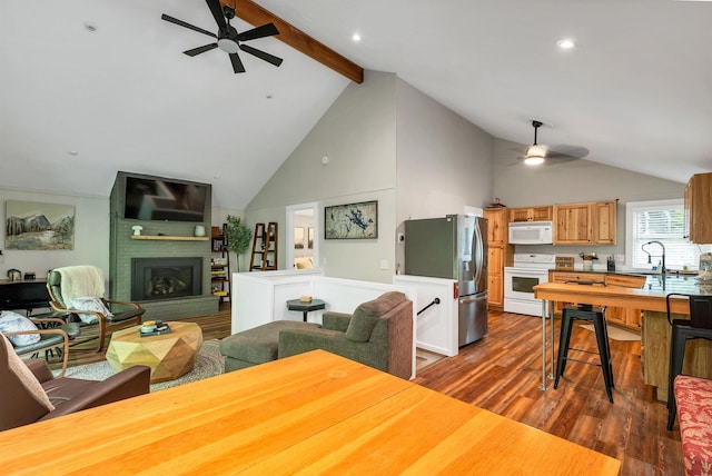 6 Chalet Dr, Gilford, NH 03249 - living area with ceiling fan, dark wood finished floors, beamed ceiling, high vaulted ceiling, and a fireplace