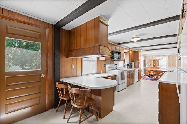 3 Patton St, Rochester, NH 03867 - kitchen with white appliances, wood walls, brown cabinetry, light countertops, and a peninsula