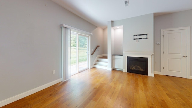 5 Callaway Dr Unit 2, Concord, NH 03301 - unfurnished living room featuring light wood-style floors, stairs, baseboards, and a glass covered fireplace