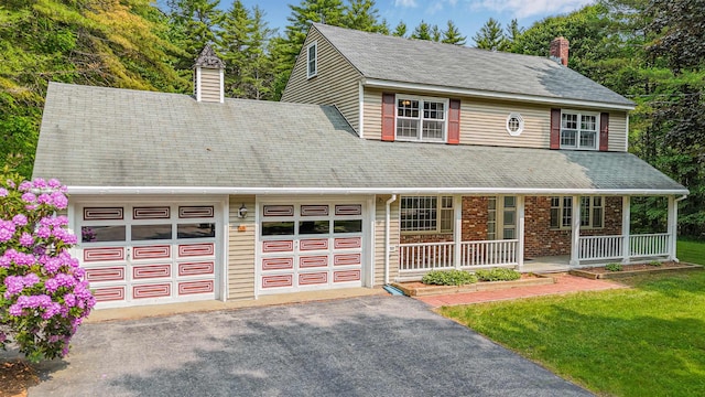 60 Hutchins St, Concord, NH 03303 - view of front facade featuring a chimney, covered porch, an attached garage, asphalt driveway, and a front yard