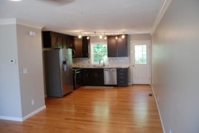 24 Bandon Cir, Westford, MA 01886 - kitchen featuring appliances with stainless steel finishes, light wood-style flooring, ornamental molding, dark brown cabinets, and tasteful backsplash