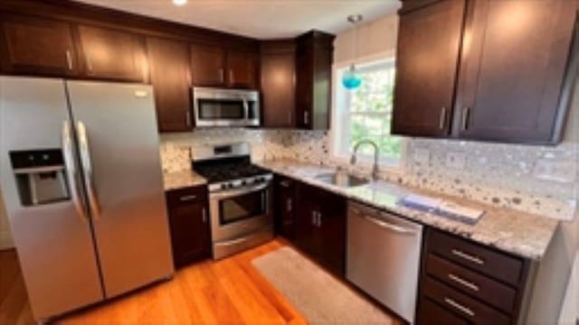 24 Bandon Cir, Westford, MA 01886 - kitchen with stainless steel appliances, a sink, tasteful backsplash, light countertops, and dark brown cabinets