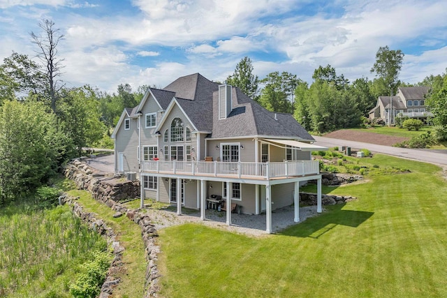 4 Mountain Ridge Dr, Meredith, NH 03253 - rear view of house featuring a wooden deck, a lawn, a shingled roof, and a patio