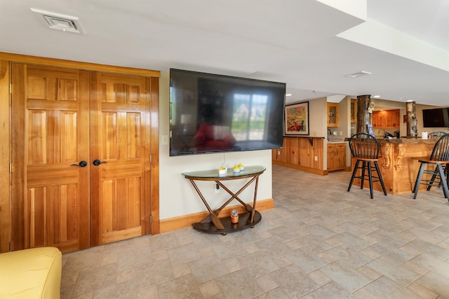 4 Mountain Ridge Dr, Meredith, NH 03253 - living area with baseboards, bar with sink, and light stone finish floors