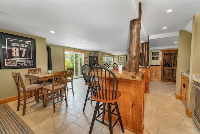 4 Mountain Ridge Dr, Meredith, NH 03253 - dining space with wet bar, recessed lighting, light stone finish flooring, and wood walls