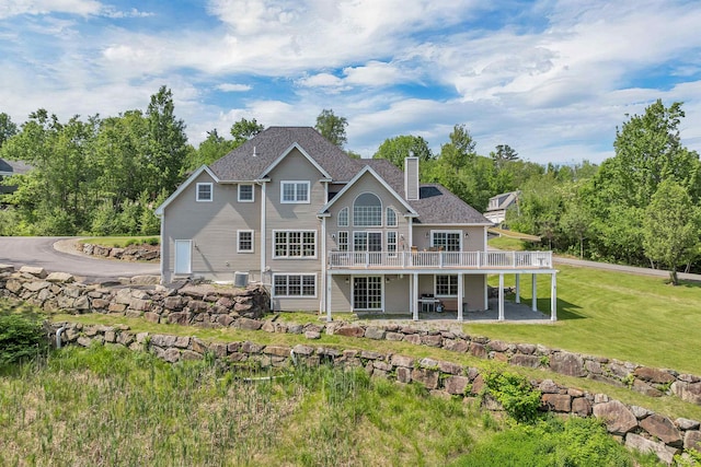4 Mountain Ridge Dr, Meredith, NH 03253 - back of house featuring a wooden deck, a chimney, a lawn, roof with shingles, and a patio area