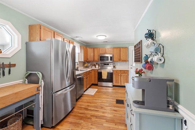 45 Cohas Ave, Manchester, NH 03109 - kitchen featuring stainless steel appliances, a sink, light wood finished floors, crown molding, and light countertops