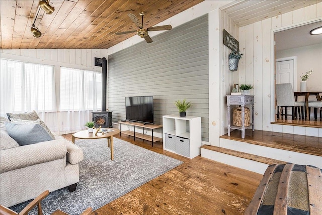 85 Lee Ave, Manchester, NH 03109 - living room featuring a wood stove, wooden walls, wood finished floors, ceiling fan, and wood ceiling