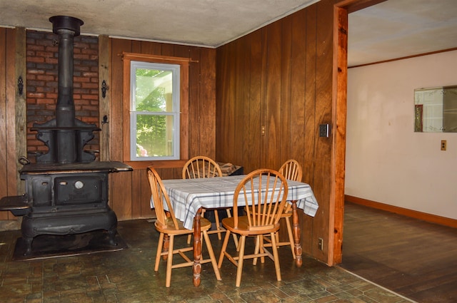 170 Brown Rd, Harrisville, NH 03450 - dining room featuring a wood stove, wooden walls, crown molding, and baseboards