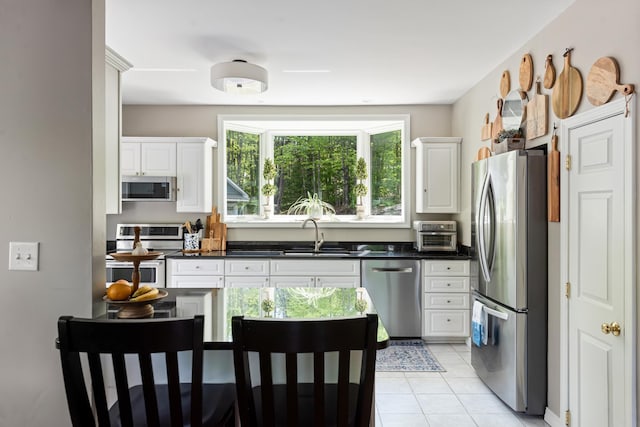 110 Heights Rd, Gilford, NH 03249 - kitchen featuring stainless steel appliances, a sink, white cabinetry, dark countertops, and light tile patterned floors