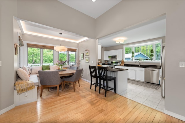 110 Heights Rd, Gilford, NH 03249 - kitchen with stainless steel appliances, white cabinetry, dark countertops, a breakfast bar area, and plenty of natural light