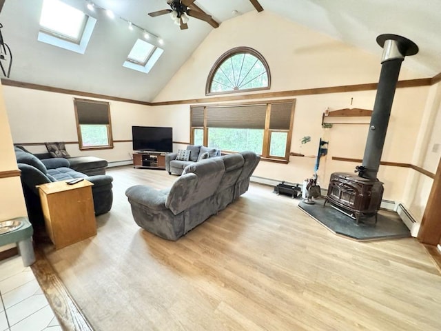 93 Faith Dr, Hampstead, NH 03841 - living area with a wood stove, track lighting, a ceiling fan, a skylight, and wood finished floors