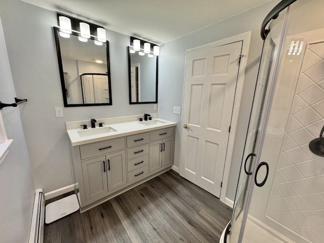 93 Faith Dr, Hampstead, NH 03841 - full bathroom with wood finished floors, a stall shower, double vanity, and baseboard heating