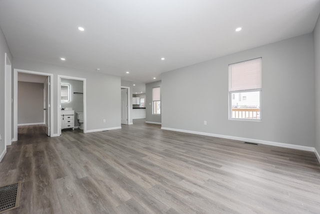 319 Mechanic St, Laconia, NH 03246 - unfurnished living room with wood finished floors, baseboards, and recessed lighting