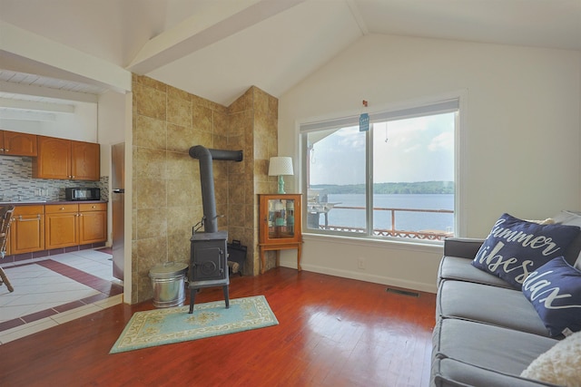 321 Webster Lake Rd, Franklin, NH 03235 - living room featuring a wood stove, lofted ceiling, wood finished floors, and baseboards