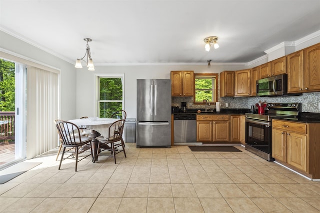 19 Wendy Dr, Alton, NH 03810 - kitchen featuring appliances with stainless steel finishes, crown molding, backsplash, dark countertops, and light tile patterned floors