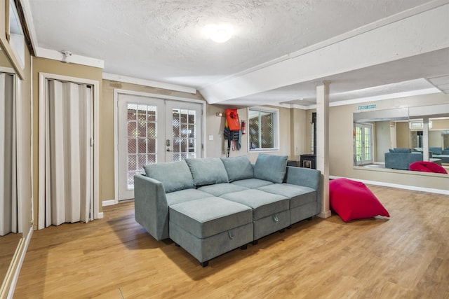19 Wendy Dr, Alton, NH 03810 - living area with light wood finished floors, french doors, a textured ceiling, and baseboards