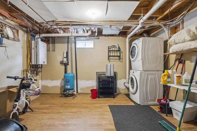 19 Wendy Dr, Alton, NH 03810 - basement featuring stacked washer and clothes dryer, water heater, a water pressure tank, and wood finished floors