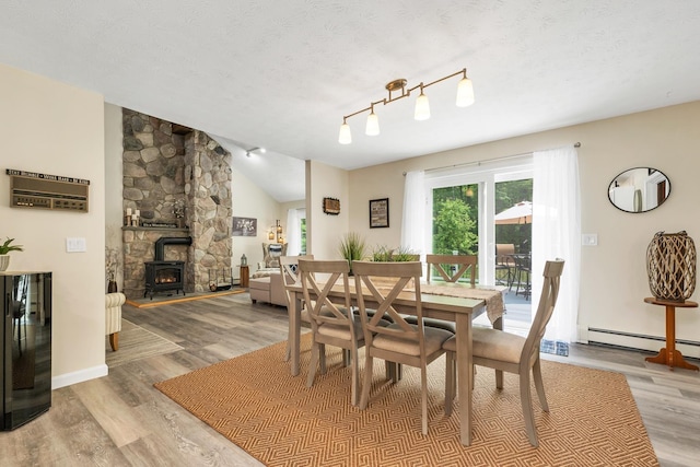 52 Meadow Ln, Belmont, NH 03220 - dining room with light wood finished floors, a baseboard heating unit, a textured ceiling, lofted ceiling, and baseboards