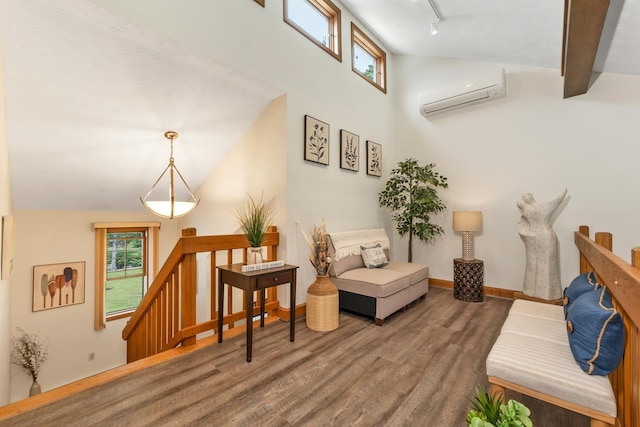 52 Meadow Ln, Belmont, NH 03220 - living room with a wall unit AC, wood finished floors, healthy amount of natural light, high vaulted ceiling, and rail lighting