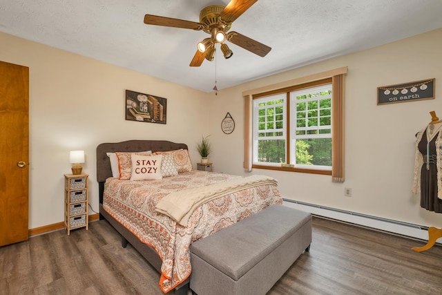52 Meadow Ln, Belmont, NH 03220 - bedroom featuring baseboard heating, wood finished floors, ceiling fan, and baseboards