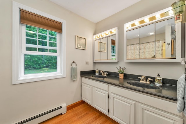 52 Meadow Ln, Belmont, NH 03220 - full bath featuring a baseboard radiator, double vanity, wood finished floors, and baseboards