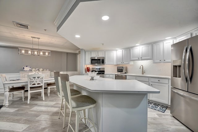 3 Sterling Hill Ln Unit 324, Exeter, NH 03833 - kitchen featuring stainless steel appliances, light countertops, light wood finished floors, a breakfast bar area, and a center island