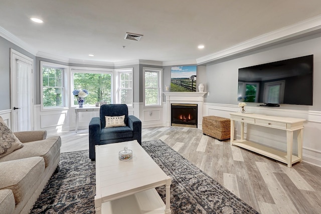 3 Sterling Hill Ln Unit 324, Exeter, NH 03833 - living room featuring crown molding, a decorative wall, light wood finished floors, a warm lit fireplace, and a wainscoted wall
