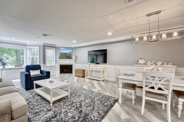 3 Sterling Hill Ln Unit 324, Exeter, NH 03833 - living area with ornamental molding, wood finished floors, a warm lit fireplace, wainscoting, and recessed lighting