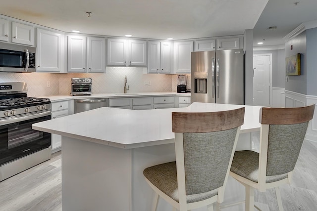 3 Sterling Hill Ln Unit 324, Exeter, NH 03833 - kitchen featuring stainless steel appliances, a sink, a center island, light countertops, and a breakfast bar