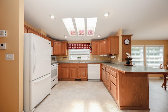 21 Mountain View Dr Unit 21, Franklin, NH 03235 - kitchen with white appliances, a peninsula, a skylight, a sink, and recessed lighting