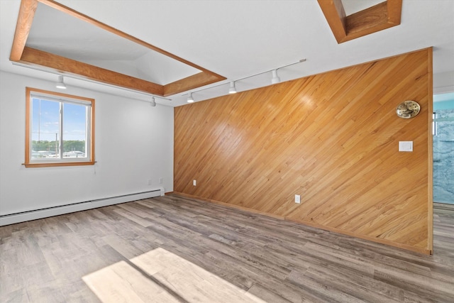 68 Kings Hwy Unit 23, Hampton, NH 03842 - unfurnished living room featuring rail lighting, a baseboard heating unit, wooden walls, wood finished floors, and an accent wall