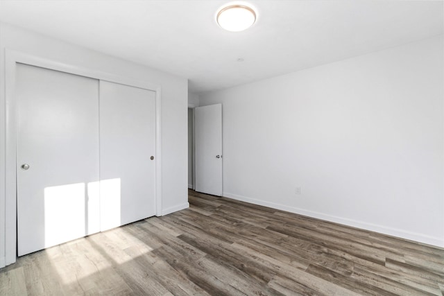 68 Kings Hwy Unit 23, Hampton, NH 03842 - unfurnished bedroom with wood finished floors, a closet, and baseboards