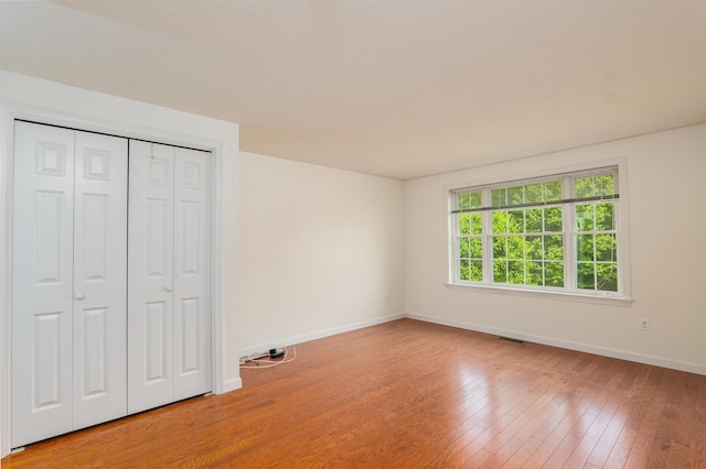 15 Christopher Dr Unit 5, Sandown, NH 03873 - unfurnished bedroom featuring baseboards, light wood-style flooring, and a closet