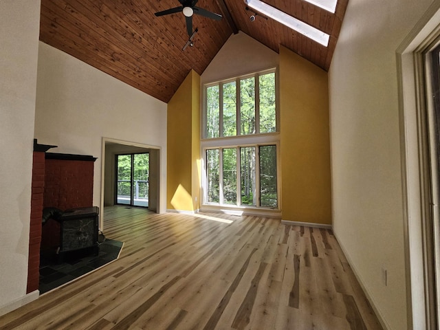 209 Craney Hill Rd, Henniker, NH 03242 - unfurnished living room with high vaulted ceiling, a ceiling fan, wood finished floors, a wood stove, and wooden ceiling with exposed beams