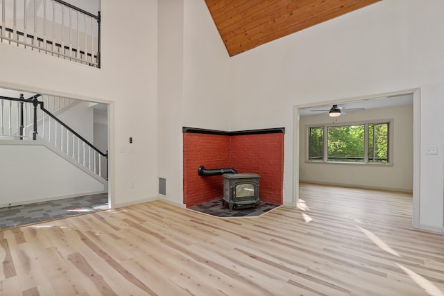 209 Craney Hill Rd, Henniker, NH 03242 - unfurnished living room featuring wood finished floors, a wood stove, high vaulted ceiling, stairs, and baseboards