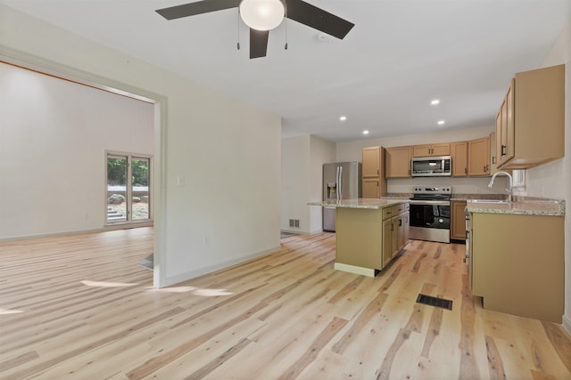 209 Craney Hill Rd, Henniker, NH 03242 - kitchen with stainless steel appliances, a kitchen island, light wood-style floors, a ceiling fan, and recessed lighting