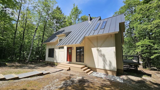 209 Craney Hill Rd, Henniker, NH 03242 - view of front of home featuring a standing seam roof, metal roof, a chimney, and stucco siding