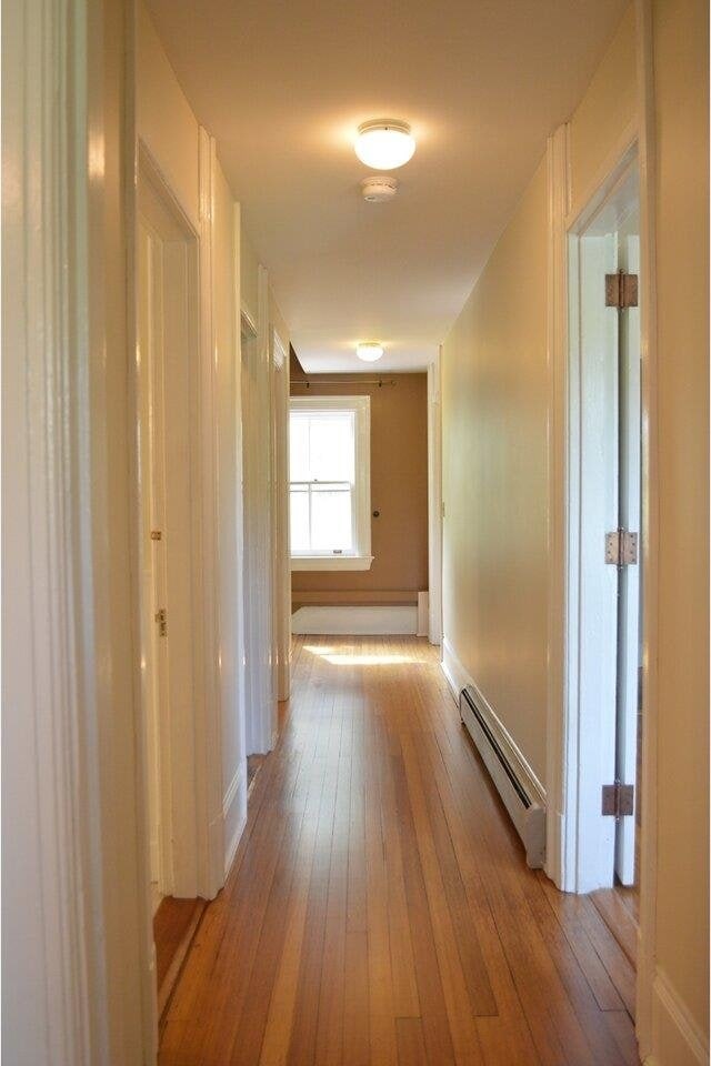 406 Dalton Dr Unit D, Colchester, VT 05446 - hall with baseboard heating, light wood-style flooring, and baseboards