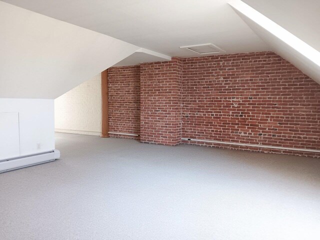 406 Dalton Dr Unit D, Colchester, VT 05446 - bonus room with vaulted ceiling, a baseboard heating unit, brick wall, and carpet floors