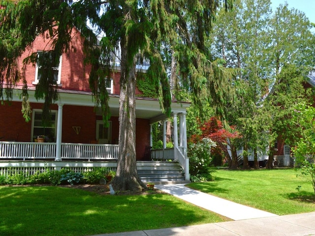 406 Dalton Dr Unit D, Colchester, VT 05446 - view of front of home with brick siding, a porch, and a front yard